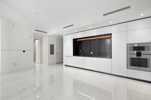 interior space featuring visible vents, white cabinets, modern cabinets, marble finish floor, and double oven