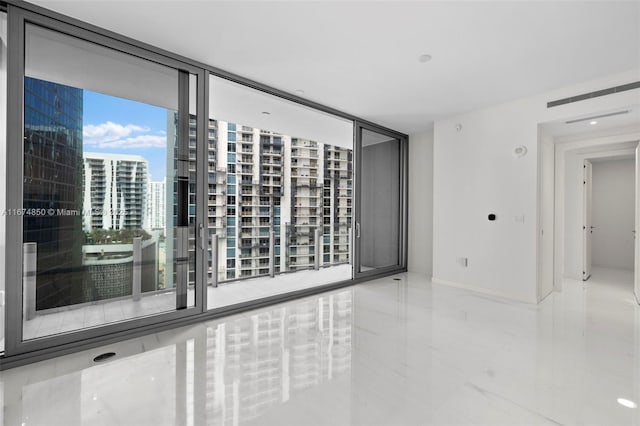 unfurnished room with marble finish floor, a view of city, and baseboards