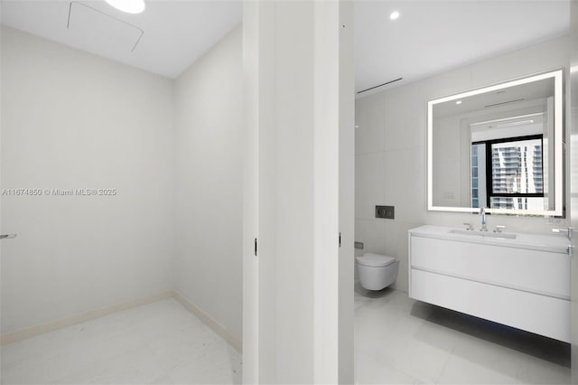 bathroom featuring baseboards, vanity, and toilet