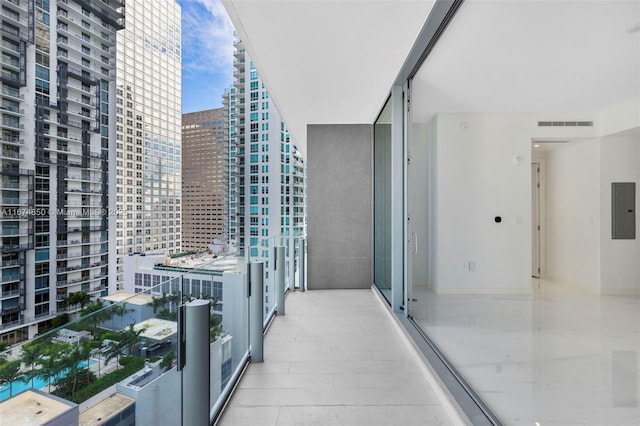 balcony featuring visible vents, electric panel, and a city view