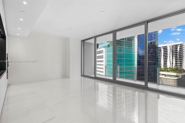 unfurnished room with a wall of windows and plenty of natural light