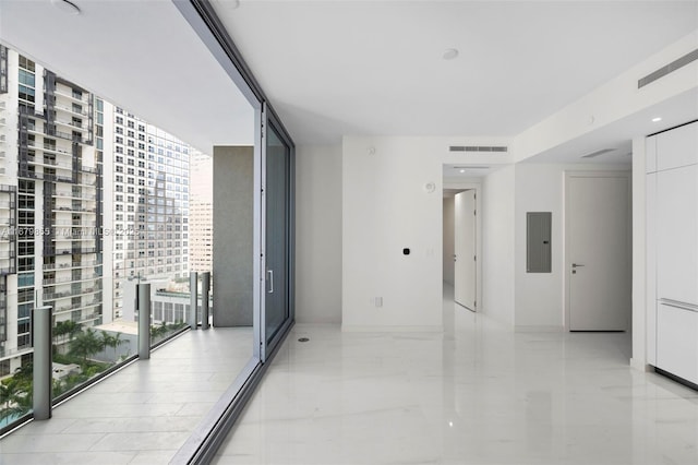 hallway with electric panel, a view of city, expansive windows, and visible vents