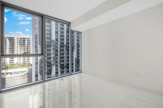 spare room with a view of city and expansive windows