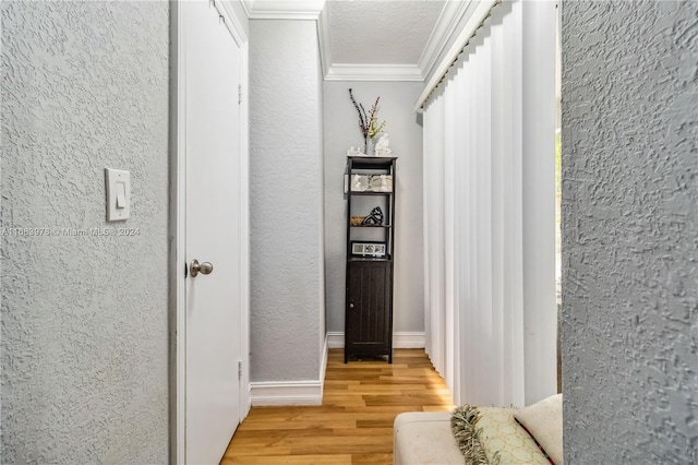 corridor featuring crown molding, hardwood / wood-style floors, and a textured ceiling