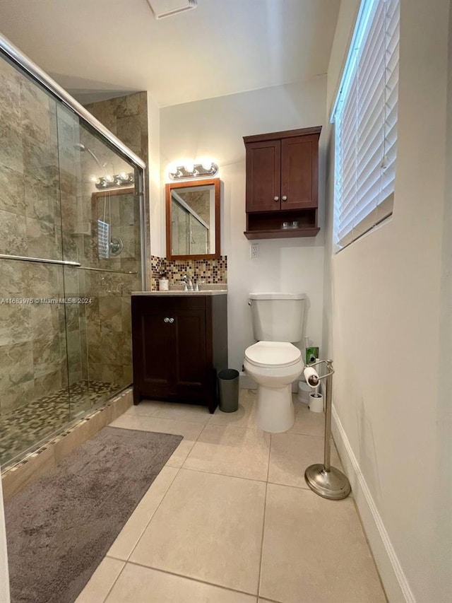 bathroom featuring a shower with door, vanity, toilet, and tile patterned flooring