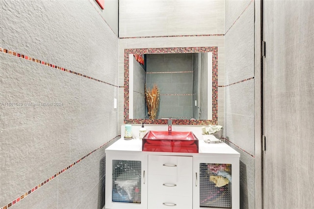 bathroom with vanity and tile walls