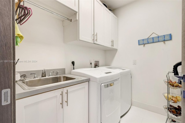 washroom featuring cabinets, light tile patterned flooring, sink, and washing machine and dryer