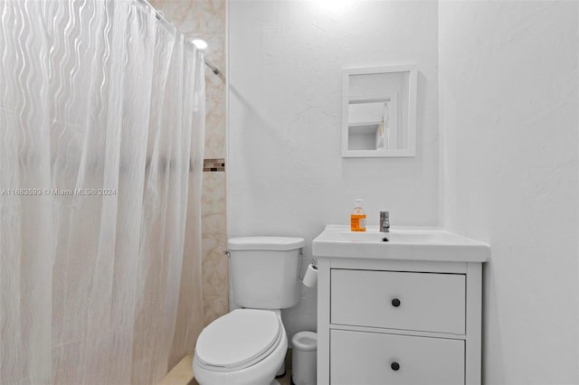 bathroom featuring vanity, curtained shower, and toilet