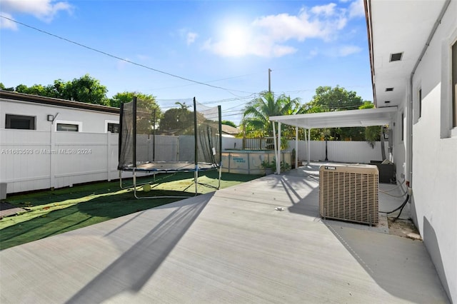 exterior space featuring central AC, a pool, and a trampoline