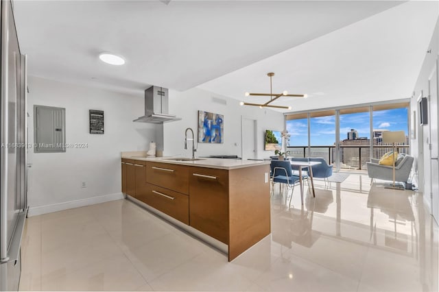 kitchen with wall chimney range hood, kitchen peninsula, an inviting chandelier, electric panel, and floor to ceiling windows