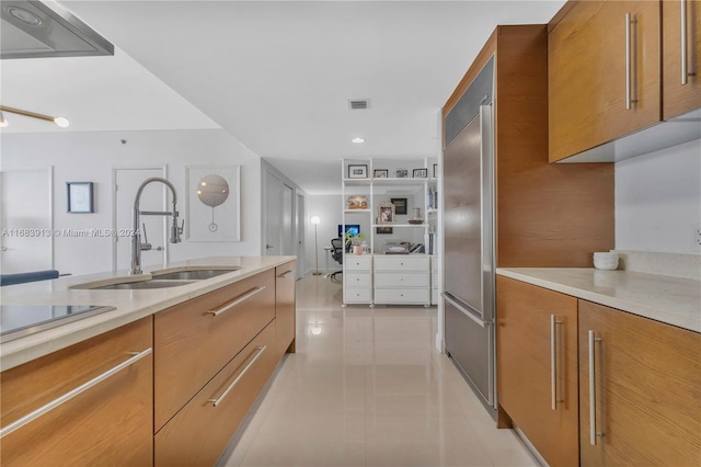 kitchen featuring light tile patterned flooring, sink, and built in refrigerator