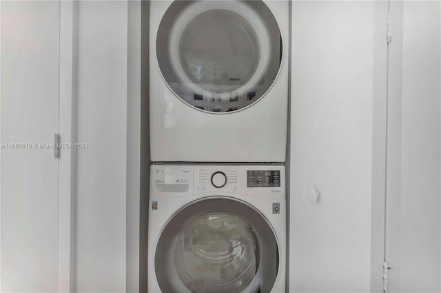 washroom featuring stacked washer and clothes dryer