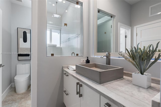 bathroom featuring vanity, toilet, and an enclosed shower