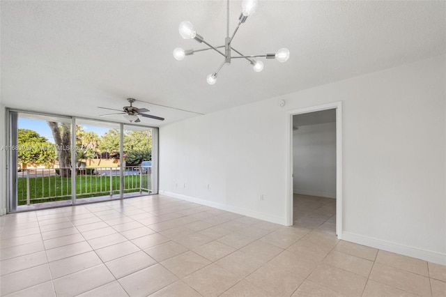 unfurnished room with a textured ceiling, light tile patterned flooring, and ceiling fan with notable chandelier