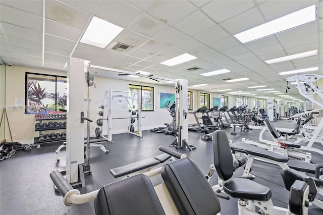 exercise room with a drop ceiling and a healthy amount of sunlight