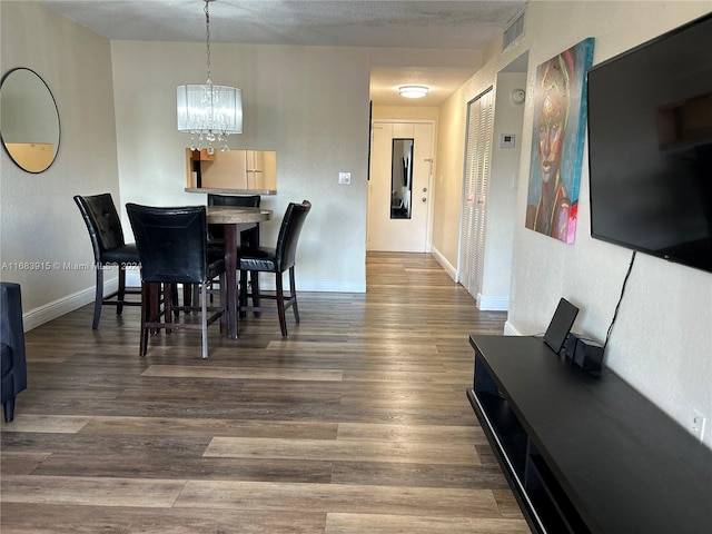 dining room with an inviting chandelier, dark hardwood / wood-style floors, and a textured ceiling