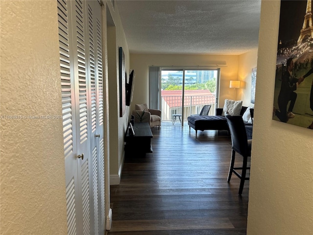 hallway with dark wood-type flooring and a textured ceiling