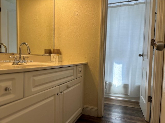 bathroom featuring vanity, wood-type flooring, and toilet