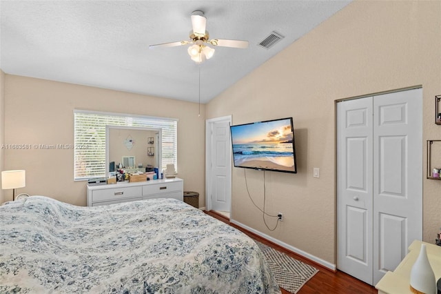 bedroom featuring ceiling fan, a textured ceiling, lofted ceiling, and dark hardwood / wood-style flooring