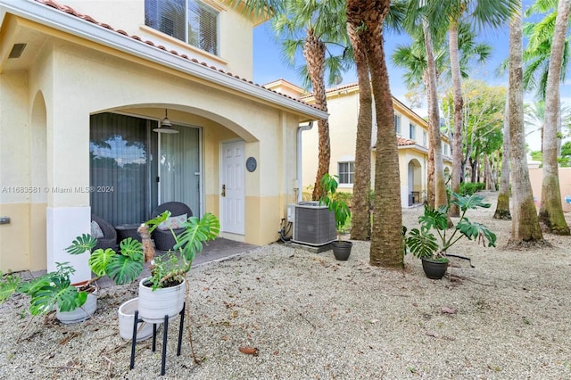 doorway to property with cooling unit and a patio area