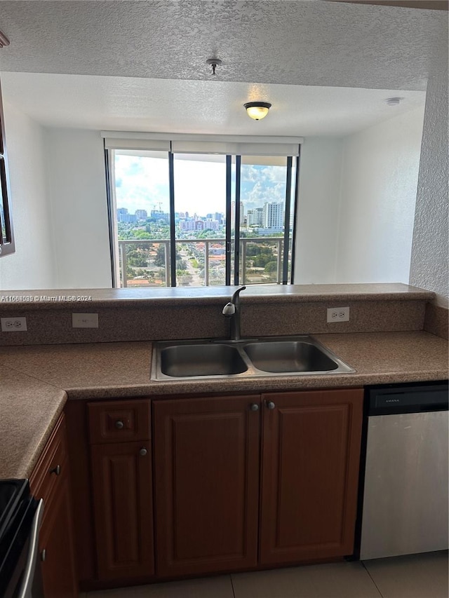 kitchen with sink, appliances with stainless steel finishes, a textured ceiling, and light tile patterned floors