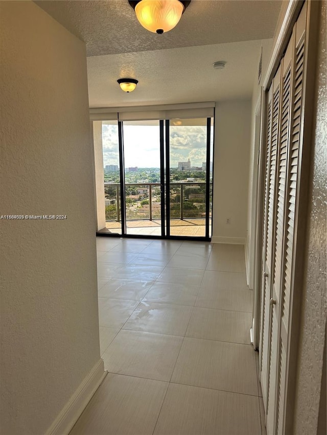 corridor featuring a textured ceiling and tile patterned flooring