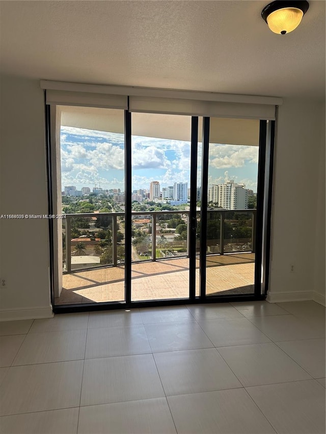 2301 SW 27th Ave Unit 1202, Miami, FL 33145 - empty room with a city view, expansive windows, and tile patterned flooring