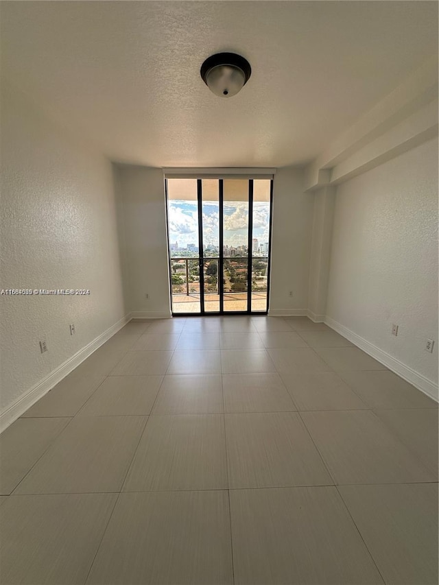 2301 SW 27th Ave Unit 1202, Miami, FL 33145 - empty room with a wall of windows, a textured ceiling, and a textured wall