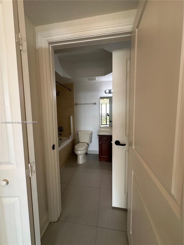 full bathroom featuring vanity, toilet, tile patterned flooring, and tiled shower / bath