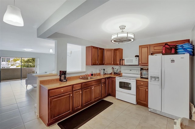 kitchen with white appliances, light tile patterned flooring, sink, and hanging light fixtures