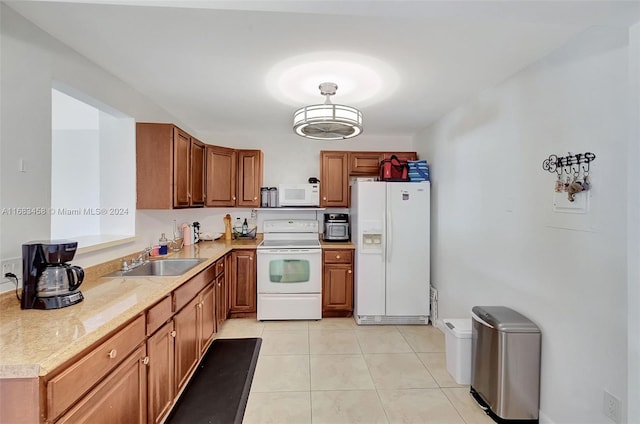 kitchen with sink, light tile patterned floors, and white appliances