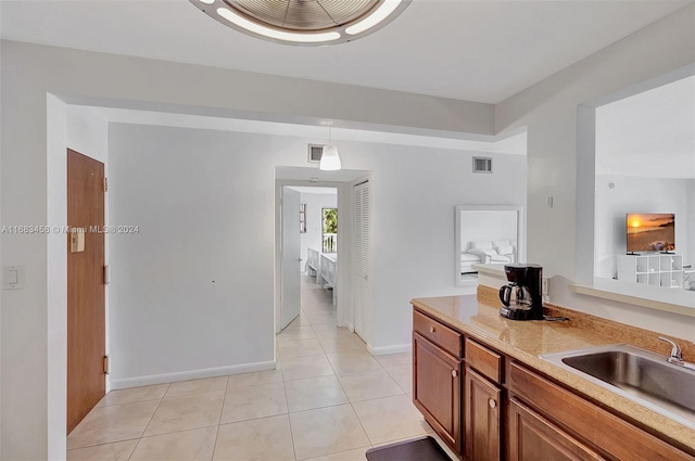 kitchen featuring sink, light tile patterned flooring, and pendant lighting