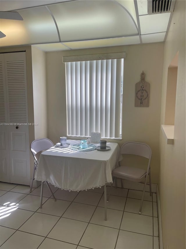 tiled dining area with a drop ceiling