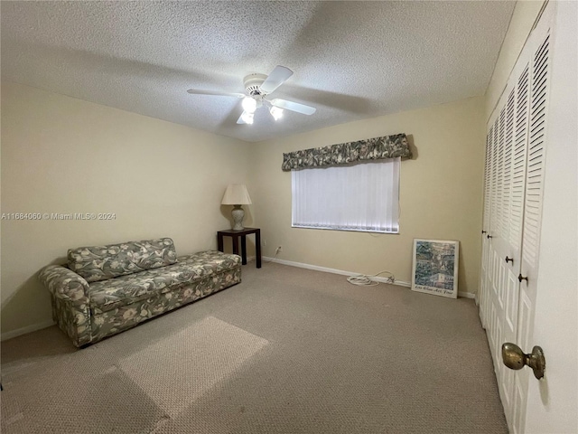 unfurnished room with ceiling fan, carpet flooring, and a textured ceiling