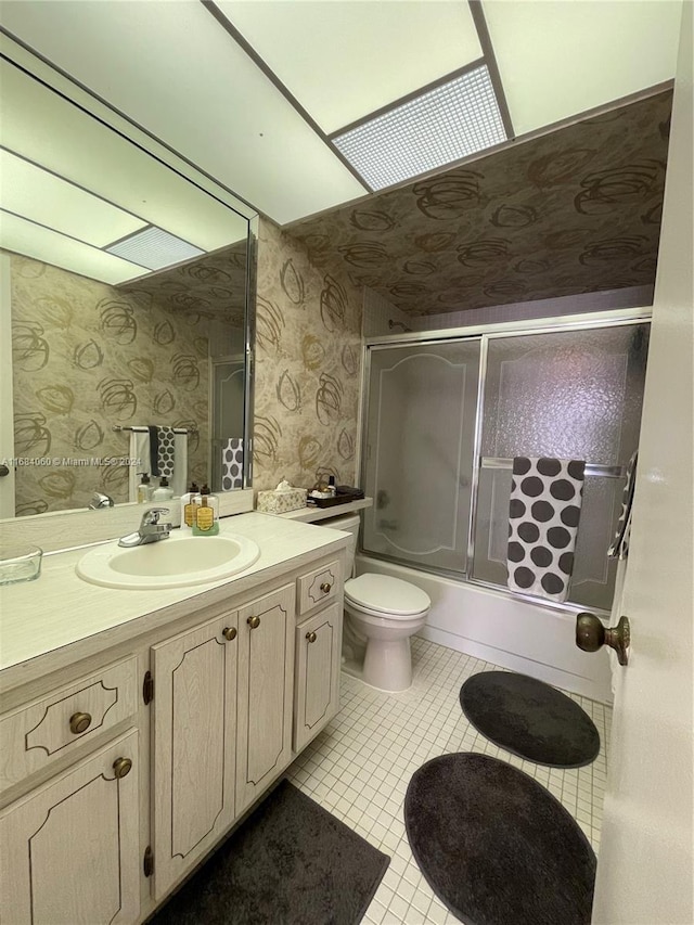 full bathroom with vanity, shower / bath combination with glass door, toilet, and tile patterned floors