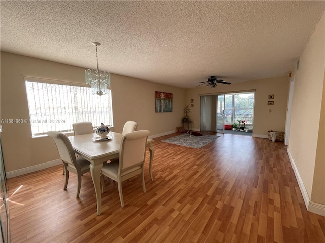 dining space featuring a textured ceiling, ceiling fan with notable chandelier, and light hardwood / wood-style floors