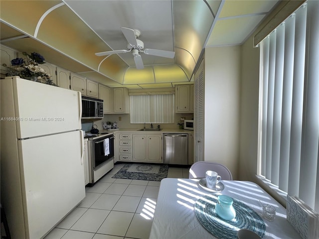 kitchen with ceiling fan, light tile patterned flooring, cream cabinetry, sink, and white appliances