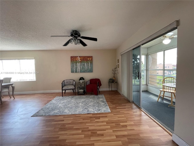 sitting room with light hardwood / wood-style flooring, a textured ceiling, ceiling fan, and a wealth of natural light