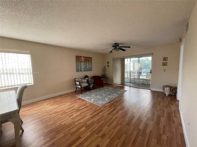 unfurnished room featuring a textured ceiling, a healthy amount of sunlight, light wood-type flooring, and ceiling fan