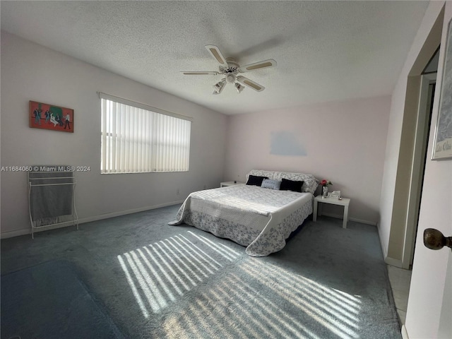 bedroom with ceiling fan, a textured ceiling, and carpet floors