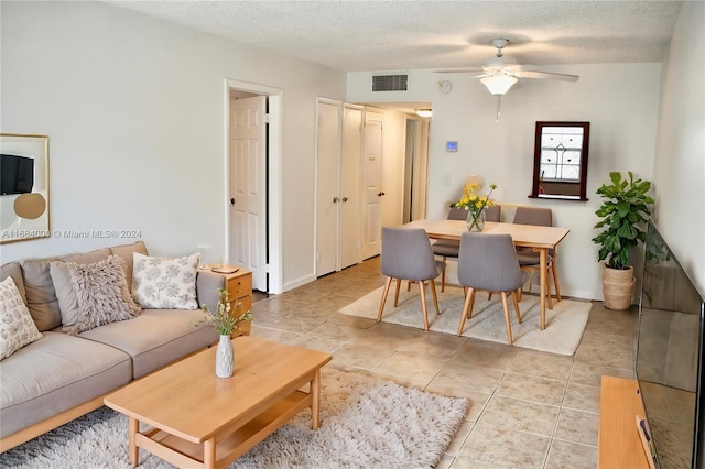 tiled living room featuring a textured ceiling and ceiling fan