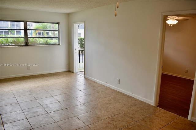 empty room featuring light hardwood / wood-style flooring, a textured ceiling, and ceiling fan