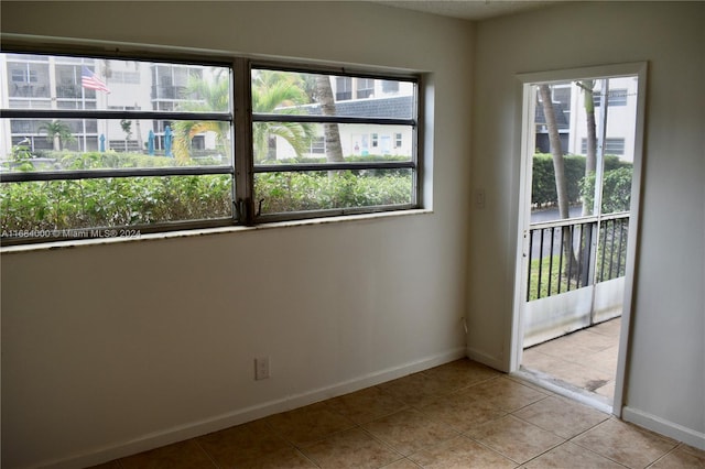 tiled empty room with a wealth of natural light