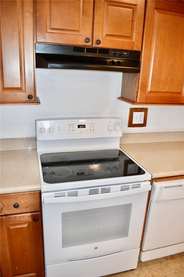 kitchen with white electric range oven and light tile patterned flooring