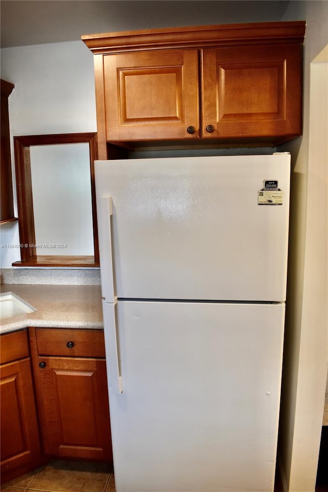 kitchen with sink, light tile patterned floors, and white refrigerator