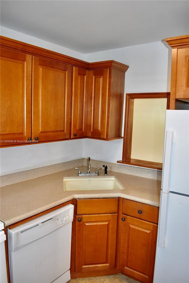 kitchen featuring sink, light tile patterned floors, and white appliances