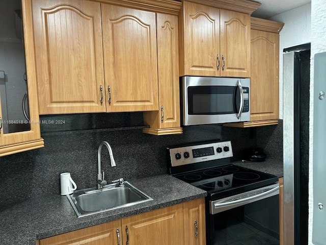 kitchen featuring backsplash, appliances with stainless steel finishes, and sink