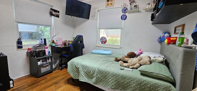 bedroom featuring wood-type flooring and multiple windows