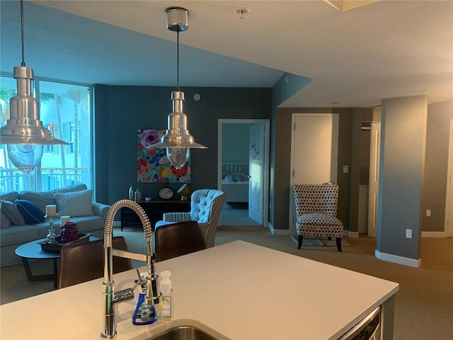 kitchen with sink, carpet, and pendant lighting