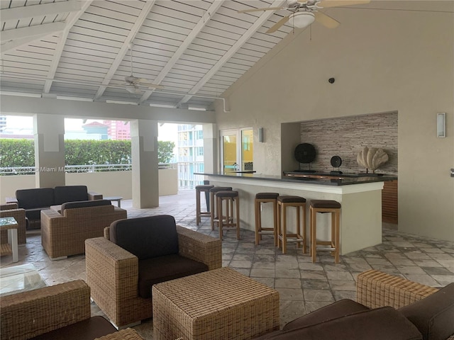 living room featuring ceiling fan, high vaulted ceiling, beam ceiling, and plenty of natural light